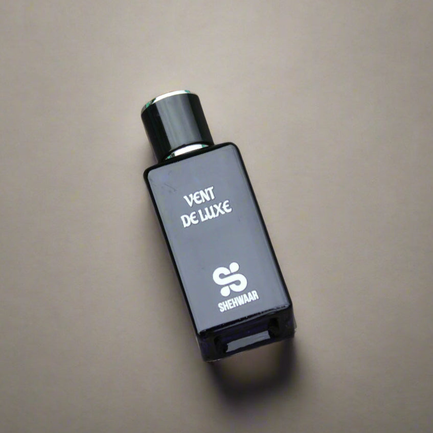 Perfume bottle labeled 'Vént de Luxe' on a textured surface
