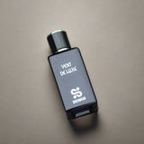 Perfume bottle labeled 'Vént de Luxe' on a textured surface